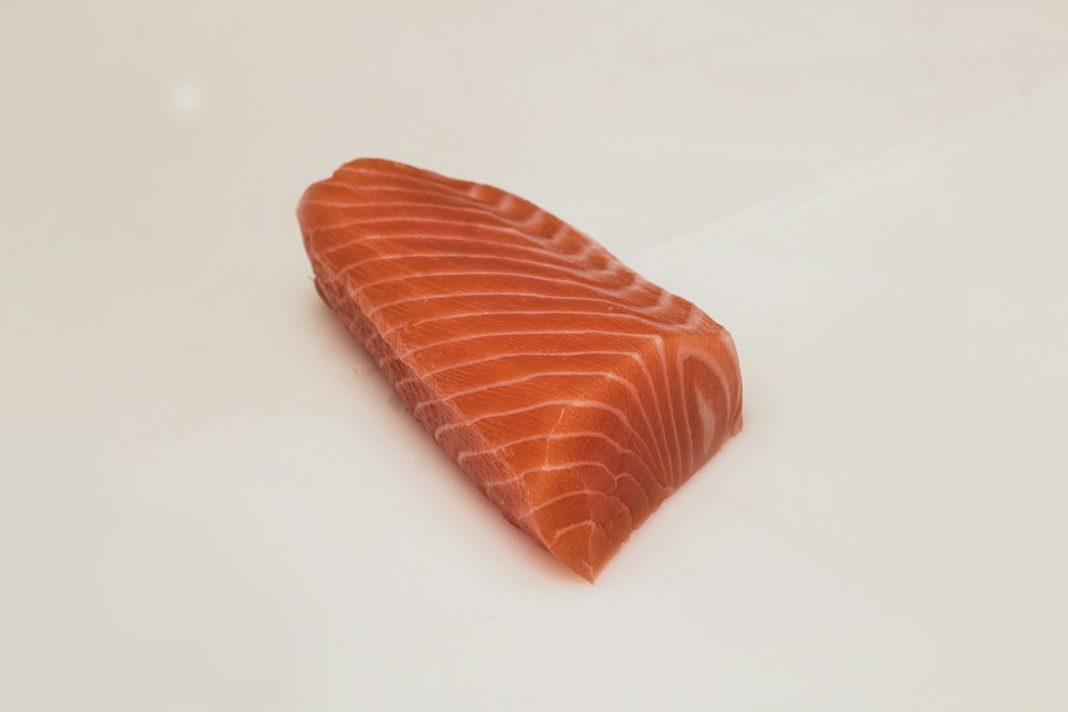 Close de um corte de salmão cru, com destaque para a textura do peixe. Imagem ilustrativa do Unsplash.